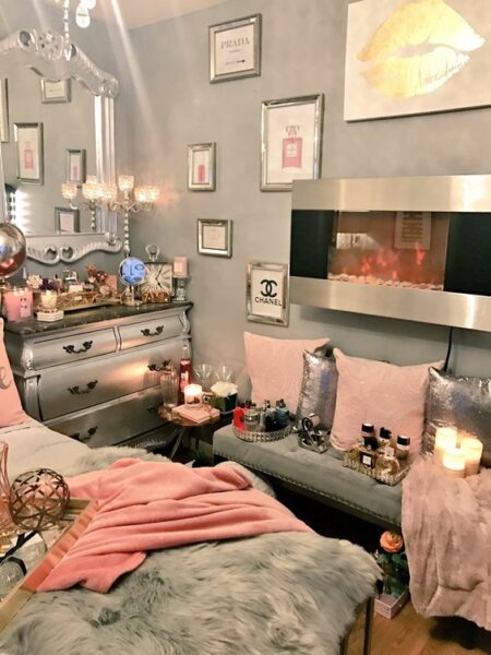 A Diva den with a bed, pillows, and a fireplace.