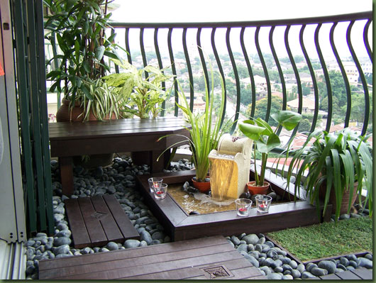 Stones and wood tiles add garden style to this balcony