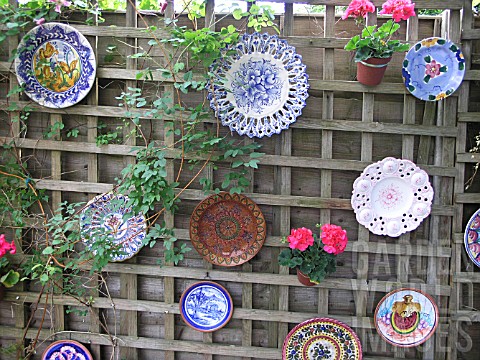 Plates decorate a garden fence 