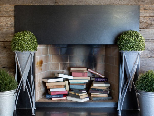 Books artfully arranged in the off-season fireplace 