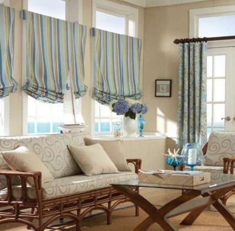 A living room with wicker furniture and striped curtains featuring window treatments.