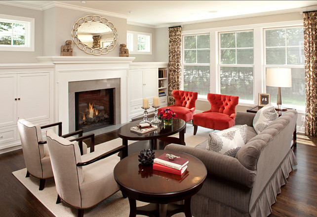 A living room with a fireplace and red chairs showcasing the basics of interior design.
