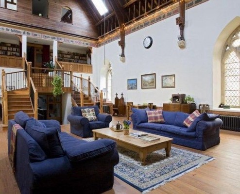 A large living room with couches and a converted fireplace.