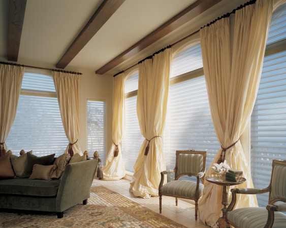 A living room with beige window treatments and a couch.
