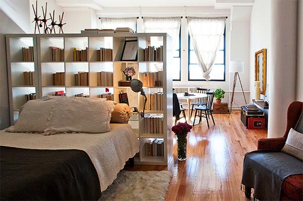 A loft bedroom with a bed and bookshelves.