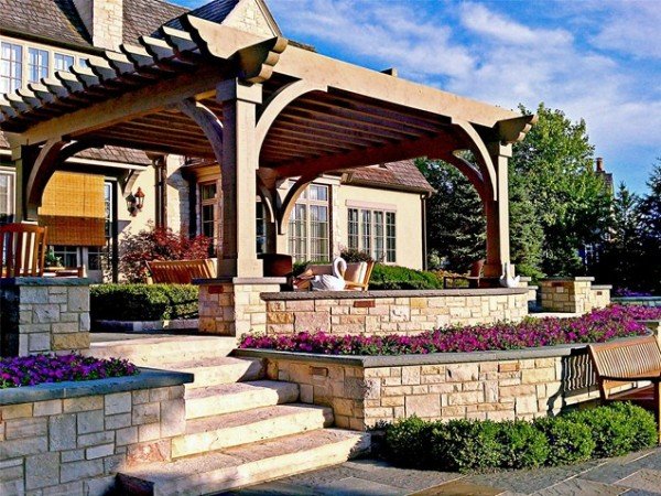 A stone patio with a wooden pergola, perfect for backyard entertaining.