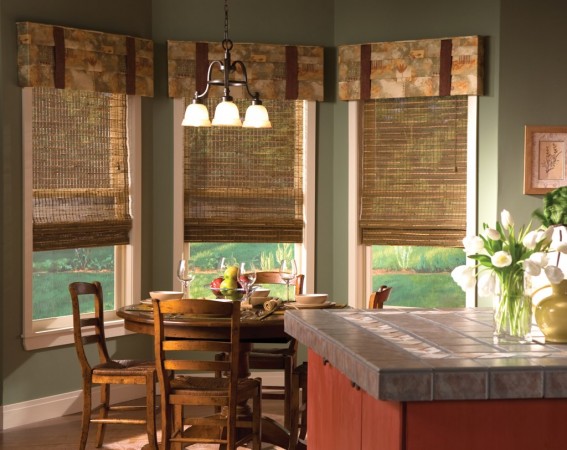 A kitchen with window treatments and a dining table.