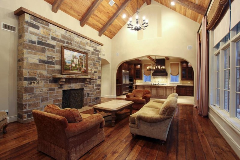 A spacious living room featuring wood floors and a stone fireplace, showcasing the beauty of natural wood in your home.