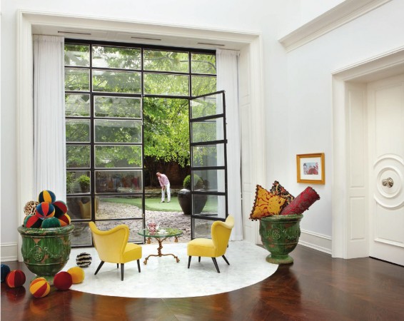 A room with whimsical yellow chairs and a glass door.