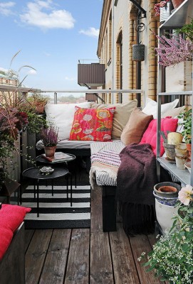 Pillows add a pop of color and cozy comfort to the balcony 