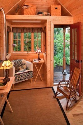 A cozy tiny house featuring a rocking chair for the ultimate tiny house living experience.