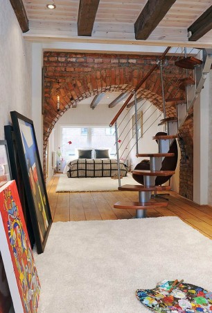 A loft space with a bed and a staircase.