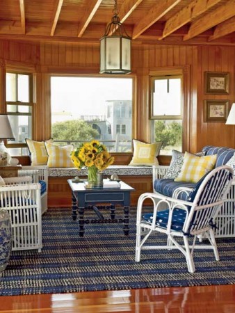 Yellow pillows and flowers highlight this blue and white room 