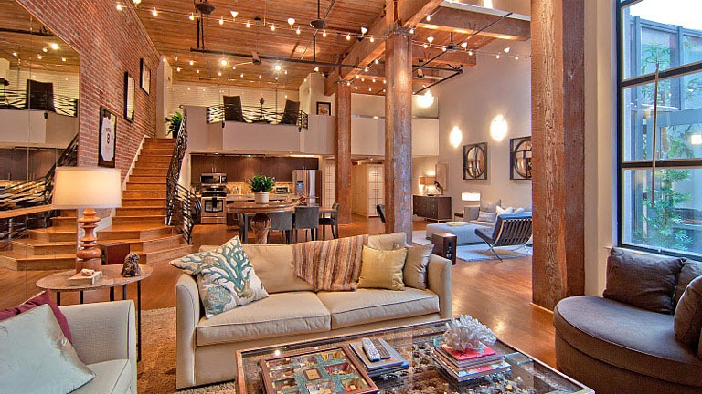 A spacious living room with abundant furniture in a warehouse to home conversion.