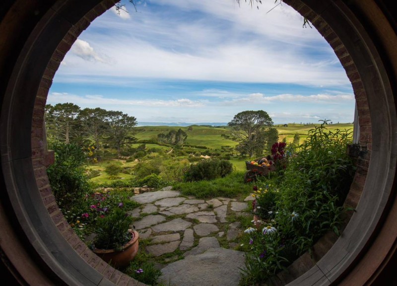 A hobbit hole with a view of a green field, experience Middle-Earth at the Hobbiton Movie Set.