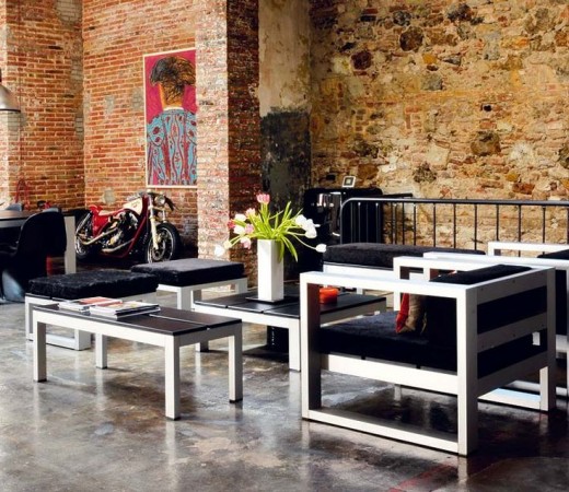 A black and white outdoor furniture set in a converted warehouse.