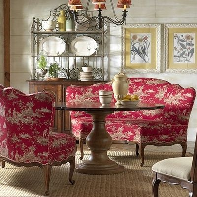 A dining room with red toile chairs and a table.