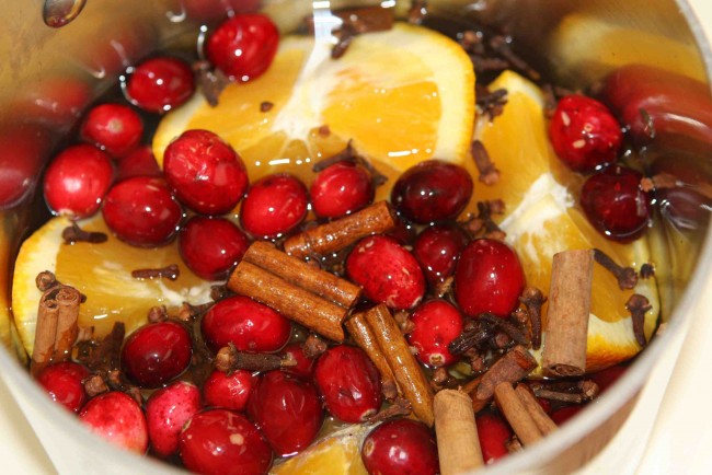 Staging your home with cranberries, oranges, and cinnamon in a pot.