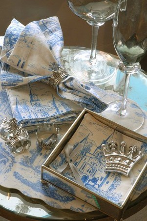 A blue and white toile napkin set on a table.