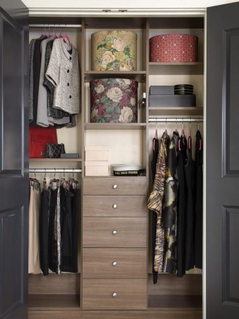 A staged closet displaying an abundance of clothes and shoes.