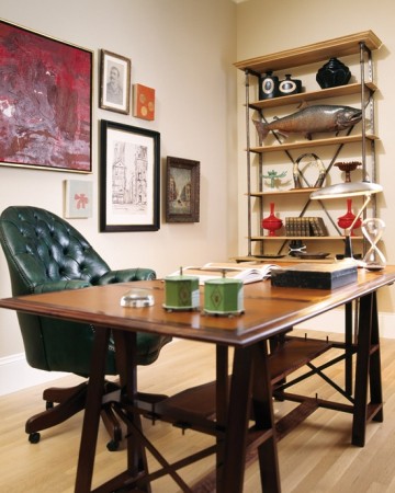 A wooden desk with a masculine green chair.