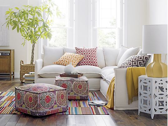 A living room with a white couch and decorative pillows.