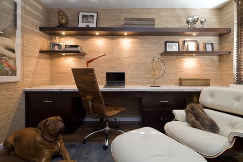 A masculine home office with a dog laying on the floor.