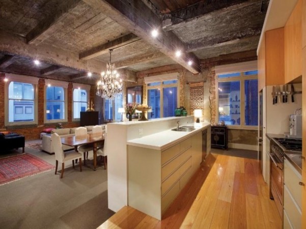 An industrial loft with an open kitchen and dining area, converted from a warehouse.