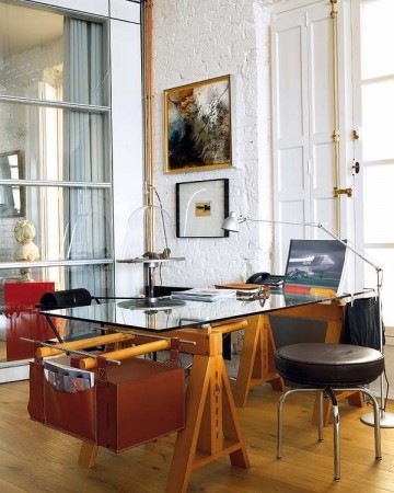 A masculine home office with a glass desk and chairs.