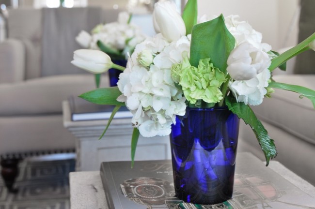A vase filled with white flowers on a coffee table, perfect for staging your home.