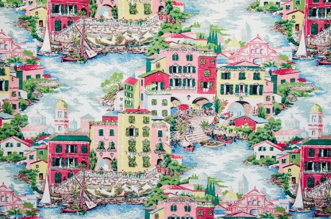A colorful toile fabric with buildings and boats on it.