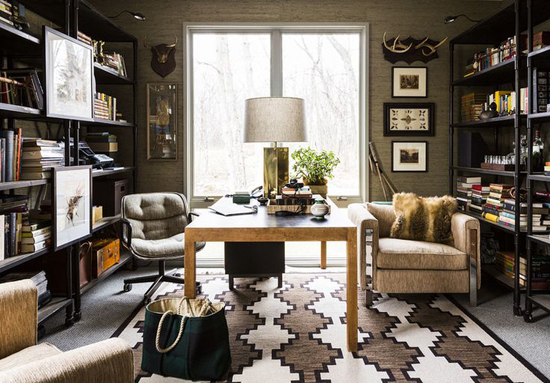 A masculine home office with bookshelves and a chair.