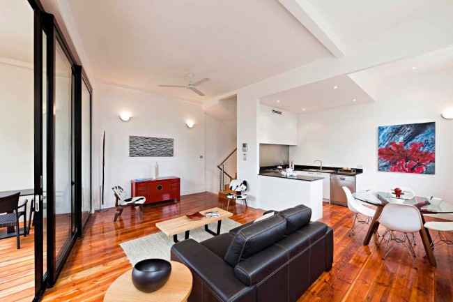 A warehouse to home conversion featuring a living room and dining room with hardwood floors.