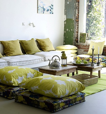 A living room with decorative yellow and green pillows.