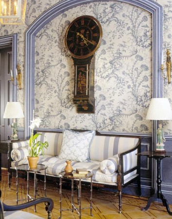 An ornate wall with a toile clock.