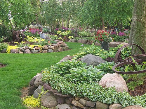 A garden with raised beds filled with rocks and flowers.