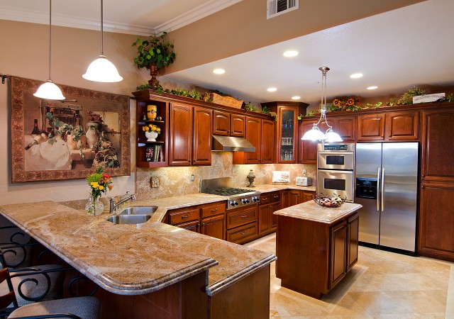A home staging with brown cabinets and granite countertops.