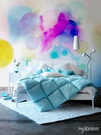 A bedroom with vibrant watercolor paint splatters on the wall.