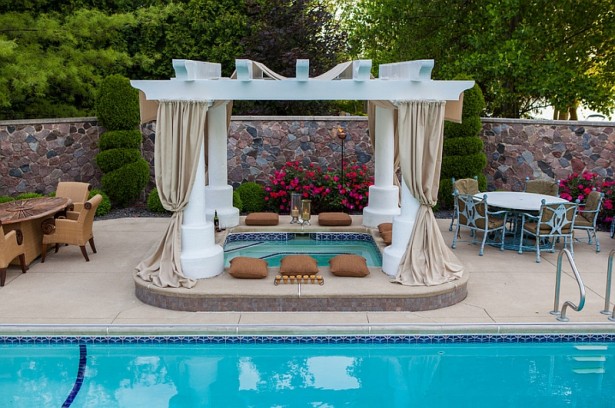 A pool area with a gazebo and furniture transformed by curtains.
