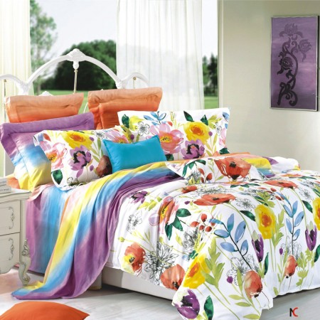 A bed with a vibrant floral comforter and pillows in a watercolor design style.