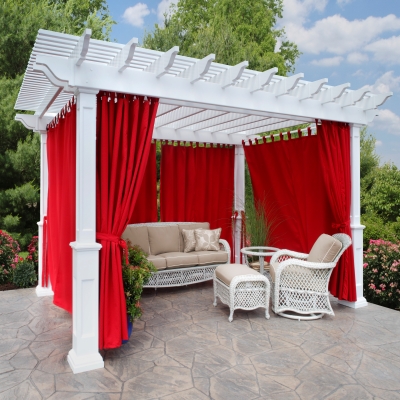 A white pergola with red curtains and wicker furniture add a pop of color to your outdoor space.