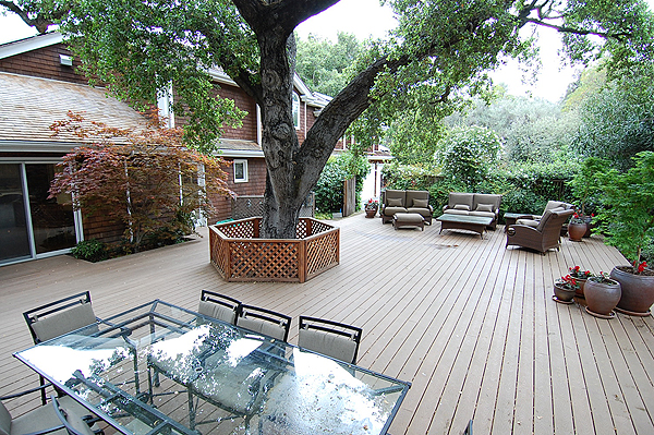 A beautiful deck area surrounds a tree