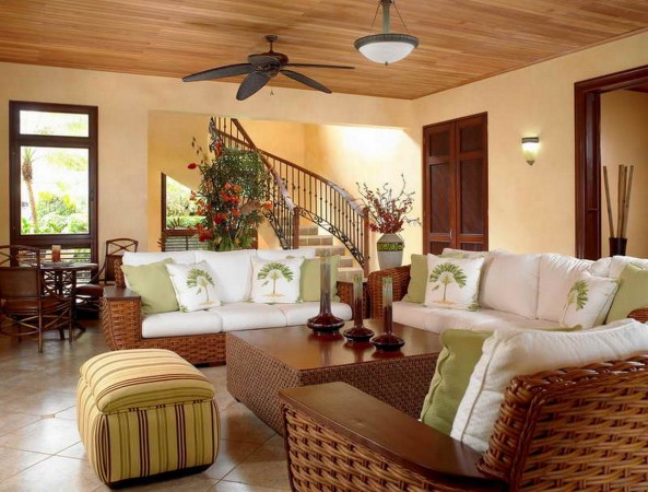 A living room with rattan furniture and a ceiling fan.