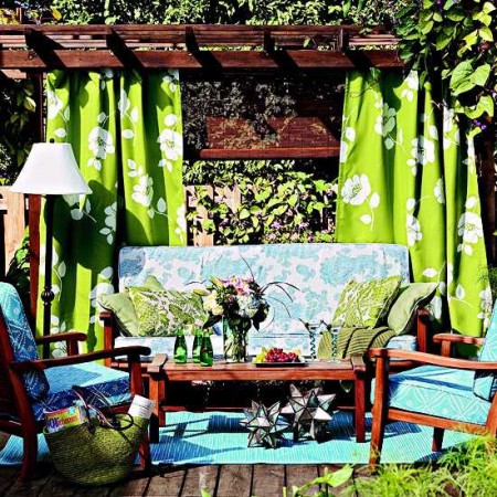 A patio with colorful curtains and stylish furniture.