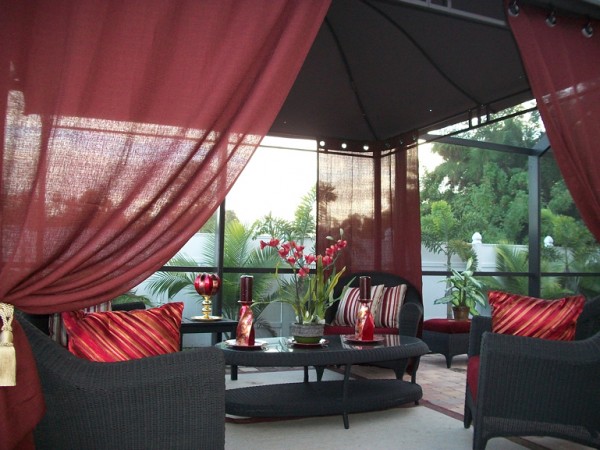 A gazebo with vibrant red curtains to enhance your outdoor space.