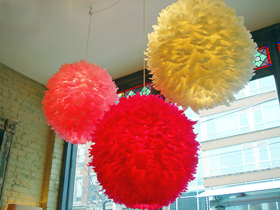 Three paper lanterns hanging in a window, feathering your nest.
