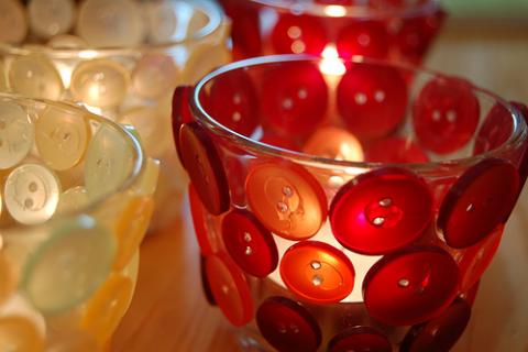 A collection of decorative candle holders featuring buttons.
