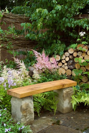 Stone and wood bench is a simple accent for the garden 