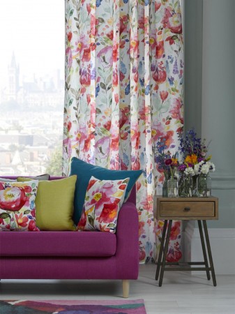 A living room with vibrant watercolor curtains and a comfortable sofa.