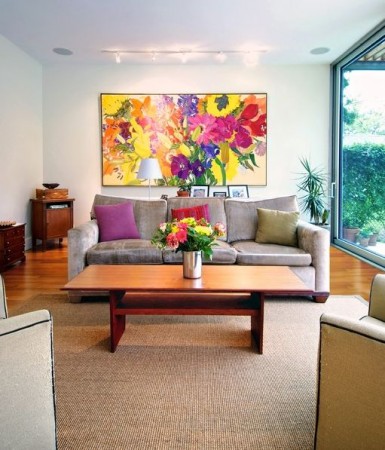 A stylish living room with a large painting on the wall.